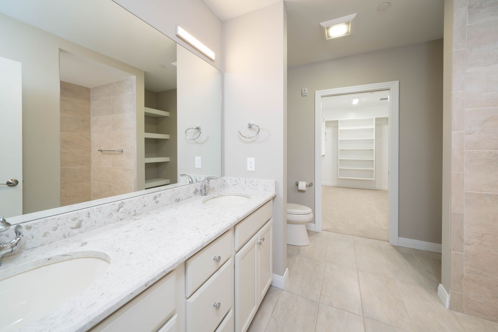 A bathroom with two sinks and a toilet
