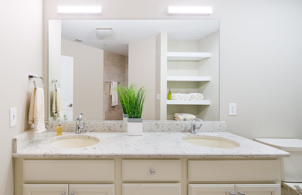 A bathroom with two sinks and a large mirror.
