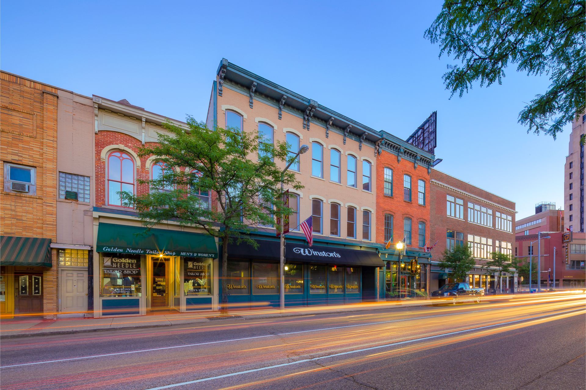 A row of buildings are lined up on a city street.