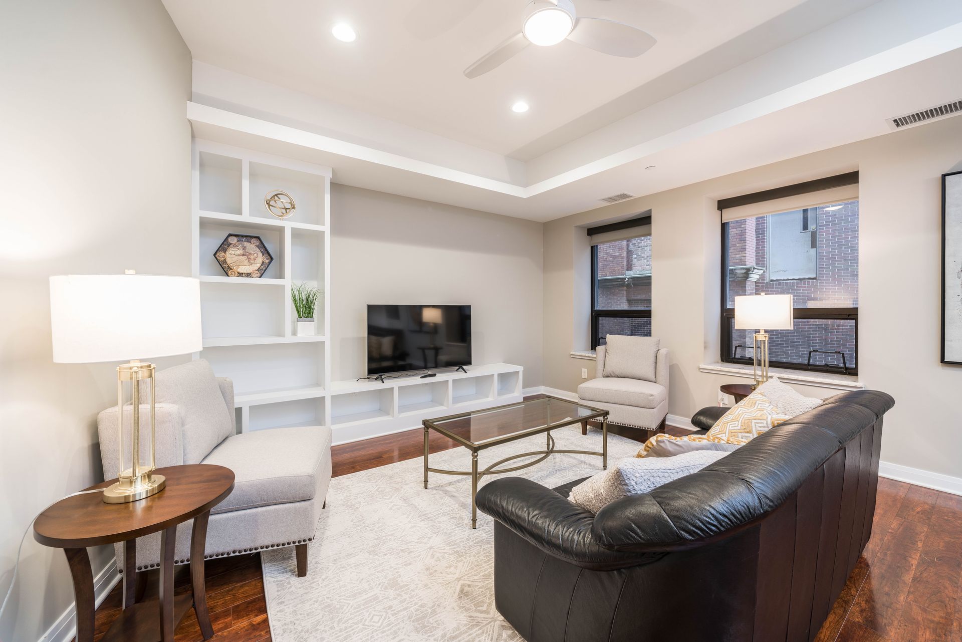 A living room with a couch , chair , coffee table and television.
