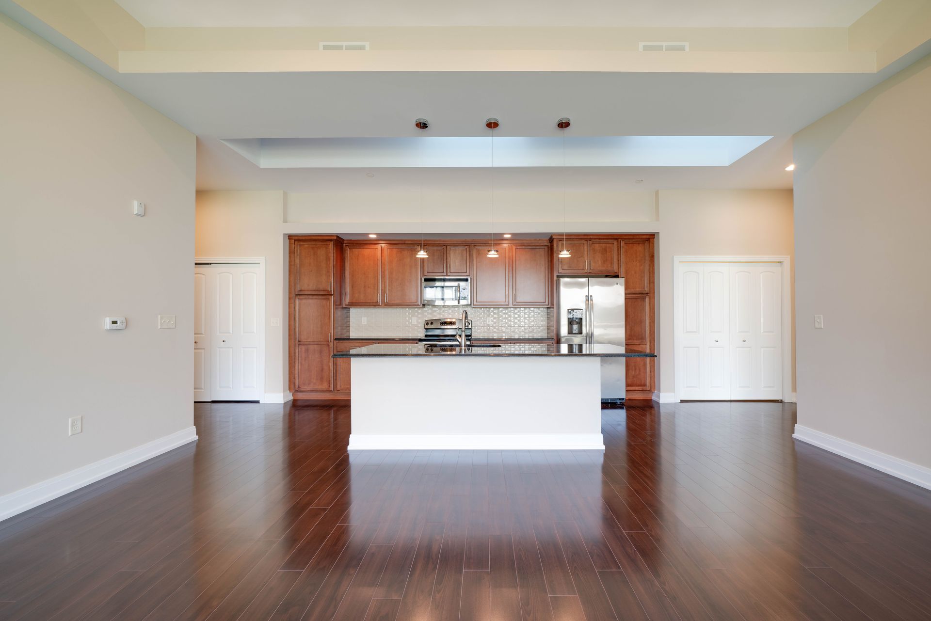 An empty kitchen with a large island in the middle