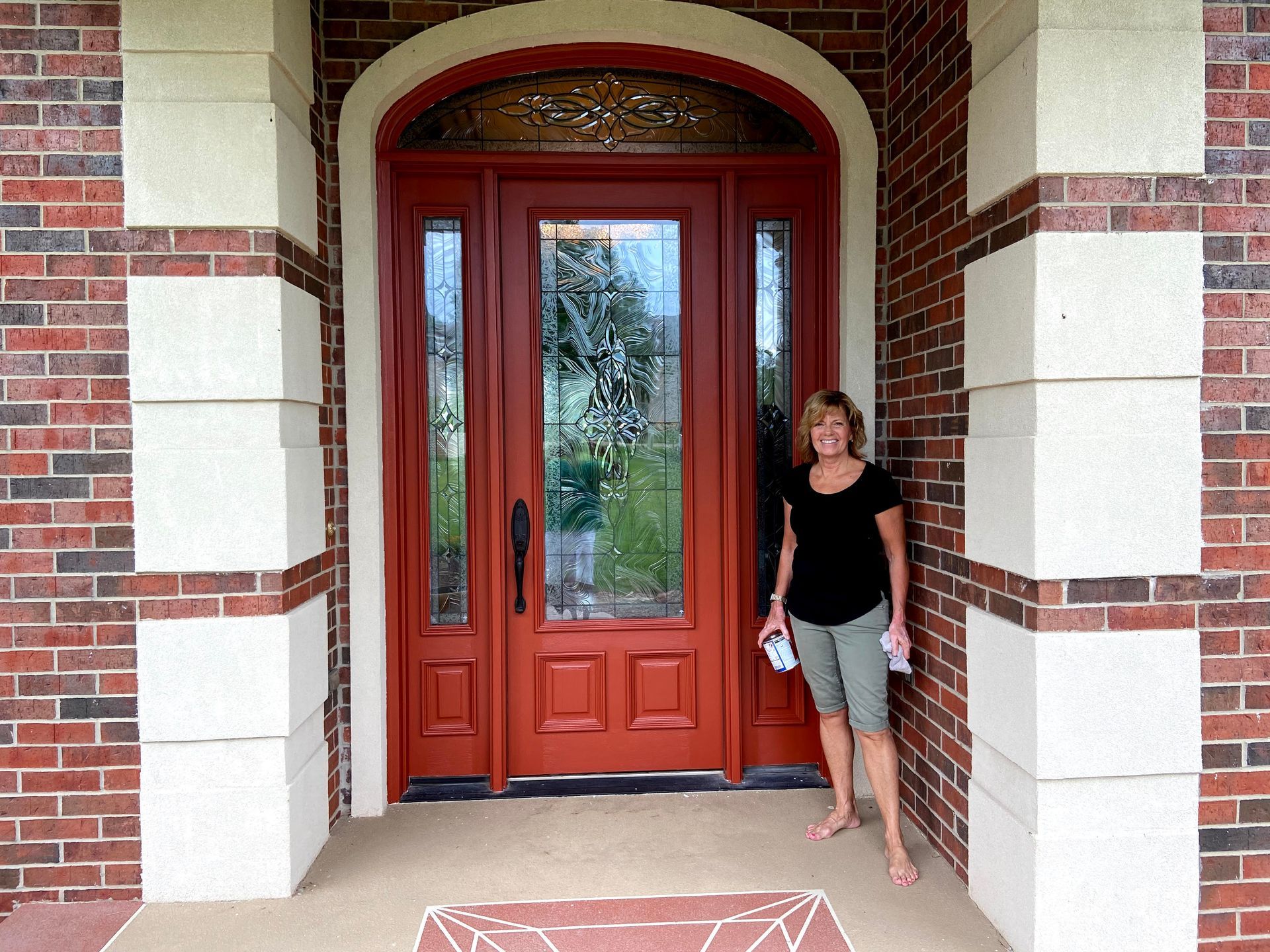 A woman is standing in front of a red door