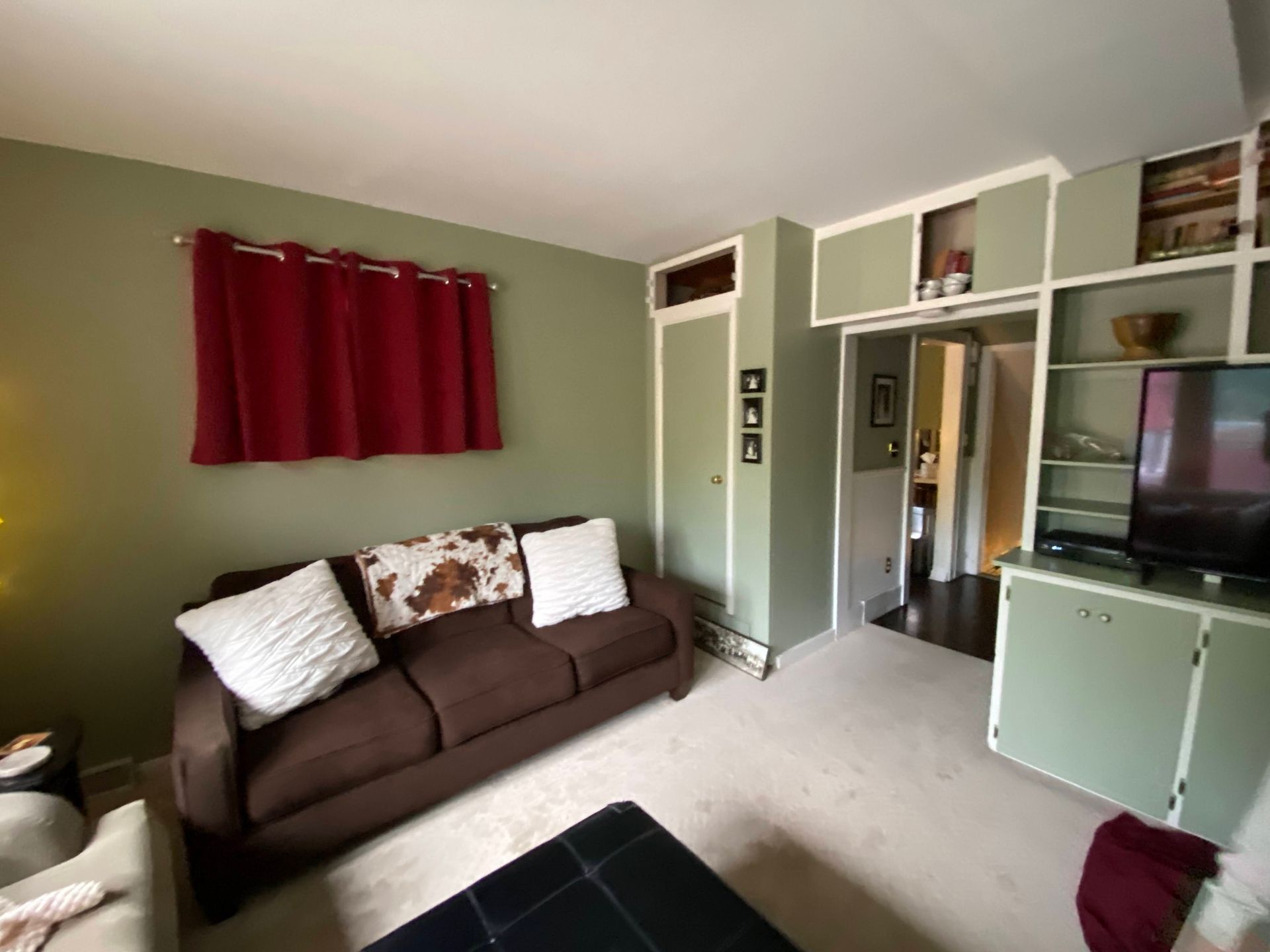 A living room with a brown couch and a flat screen tv