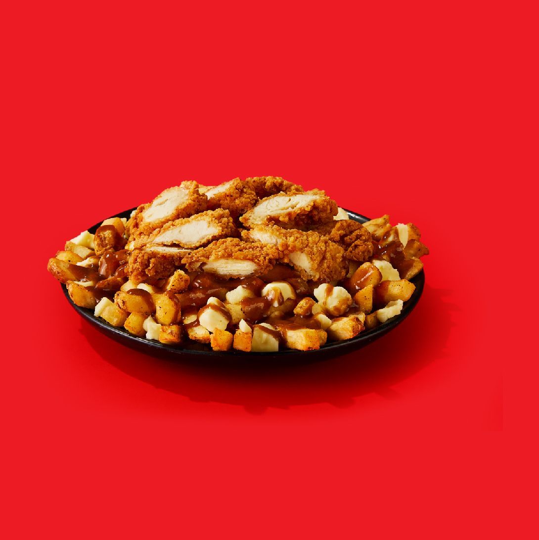 A plate of fried chicken and potatoes on a red background.