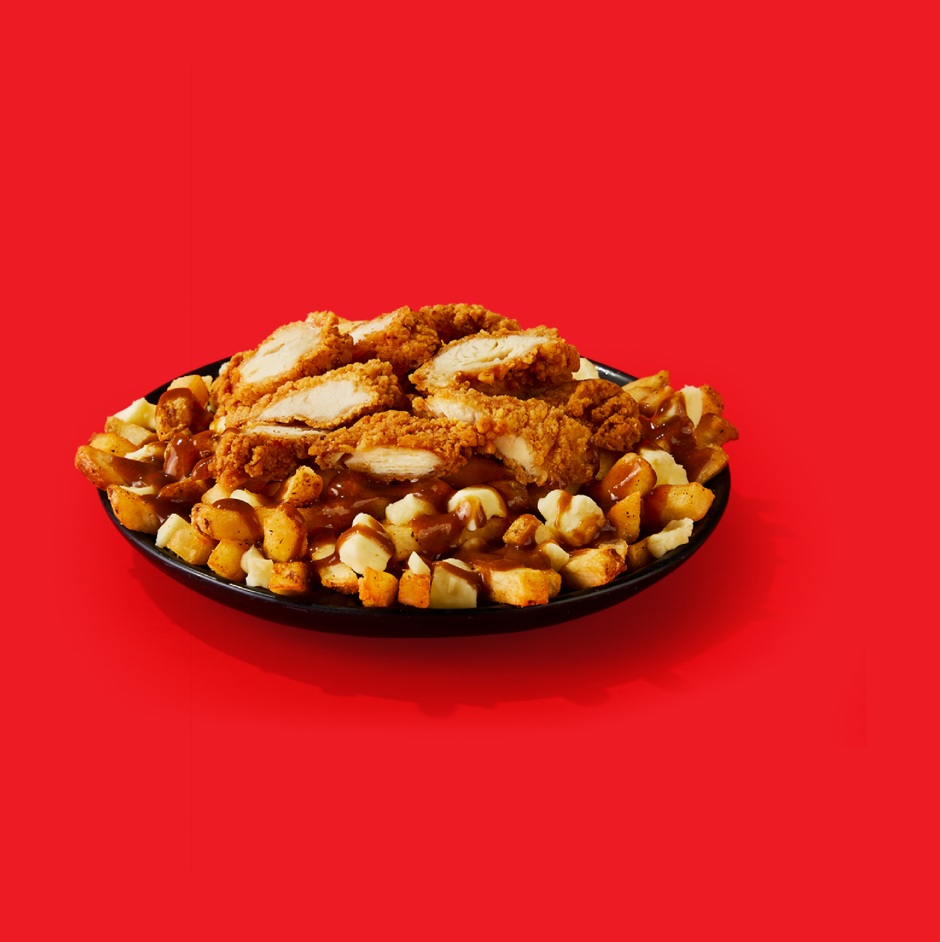 A plate of fried chicken and potatoes on a red background.
