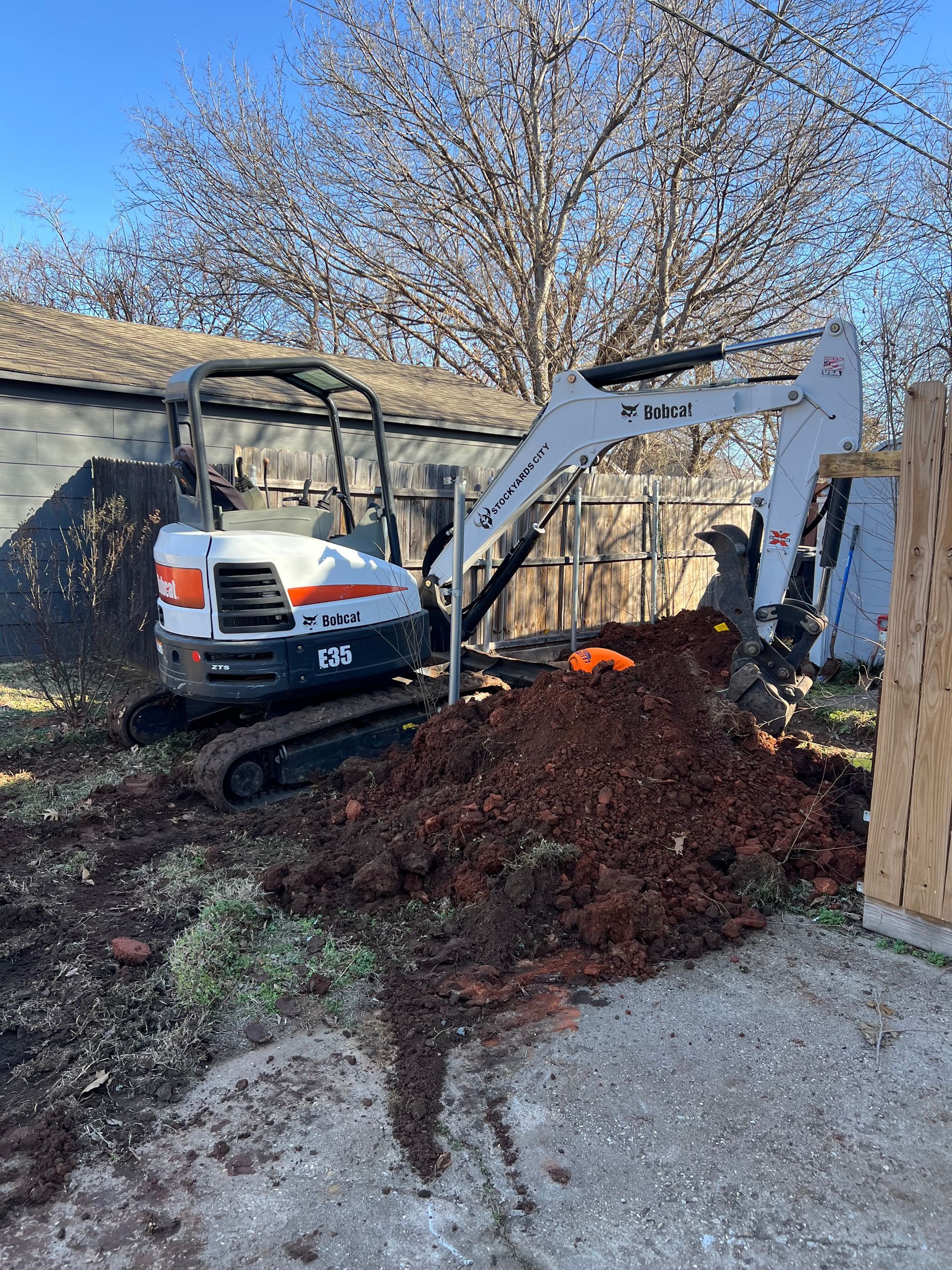 White plumbing pipes with black connector, secured by clamps, beneath stainless steel shelving. White plumbing pipes with black connector, secured by clamps, beneath stainless steel shelving.