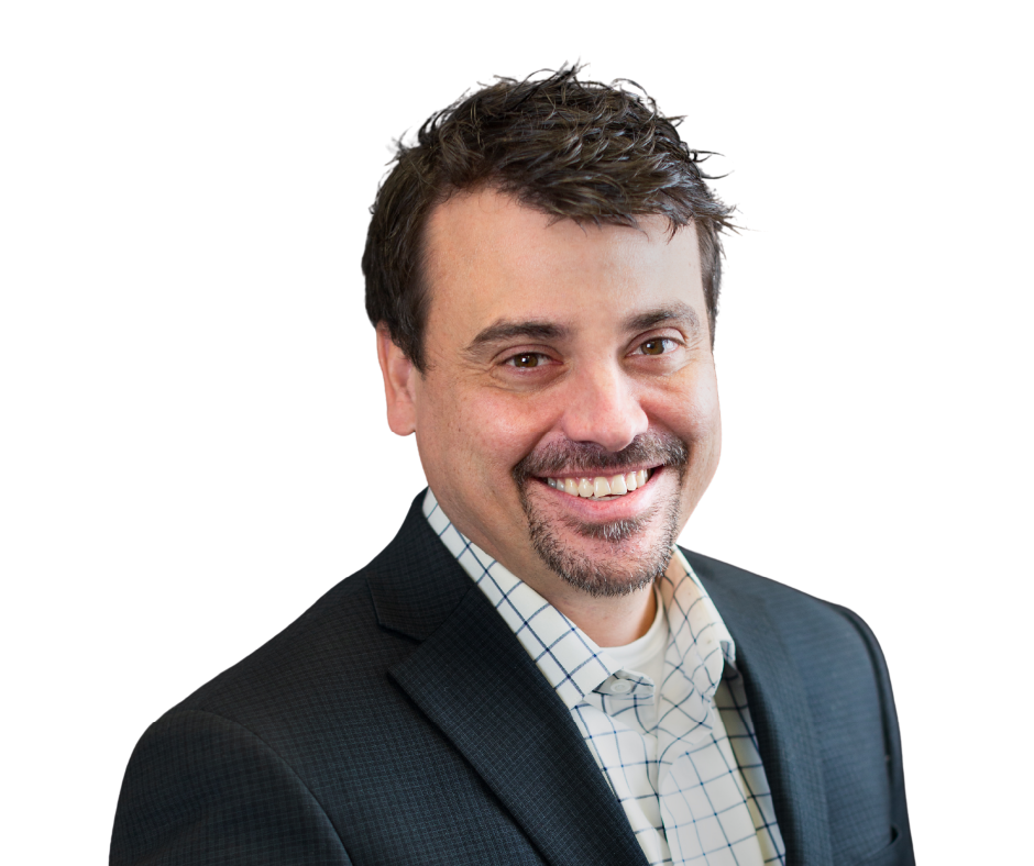 Man with brown hair, smiling, wearing blue patterned shirt and checkered blazer.