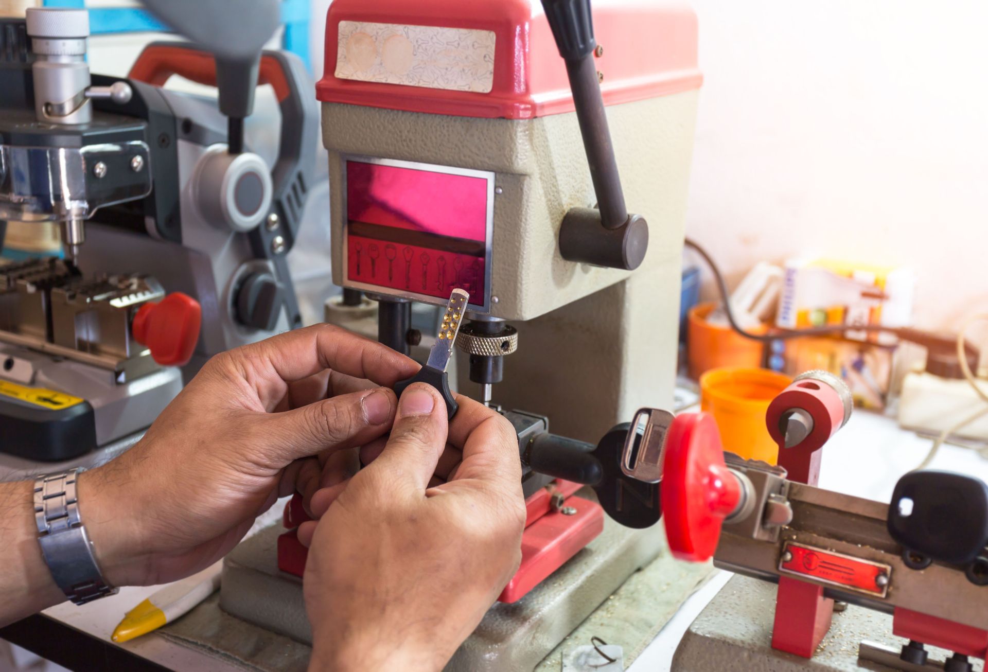 Person using key cutting machine, preparing to cut a new key.