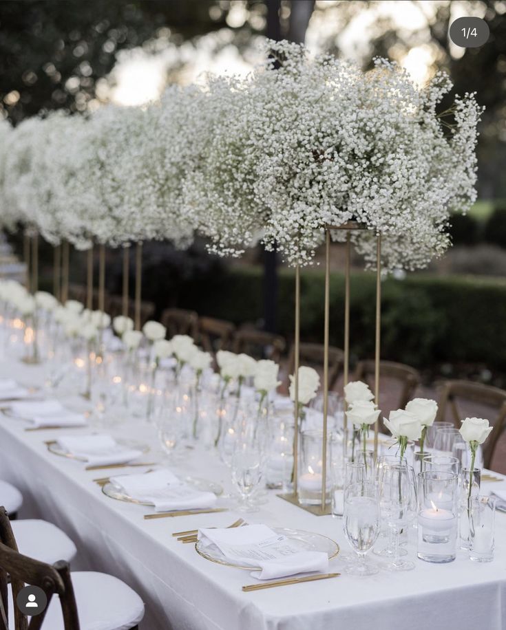 Una sposa in abito bianco tiene in mano un bouquet di fiori bianchi.