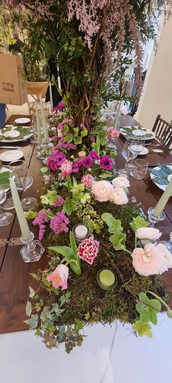 Un lungo tavolo con fiori e candele.