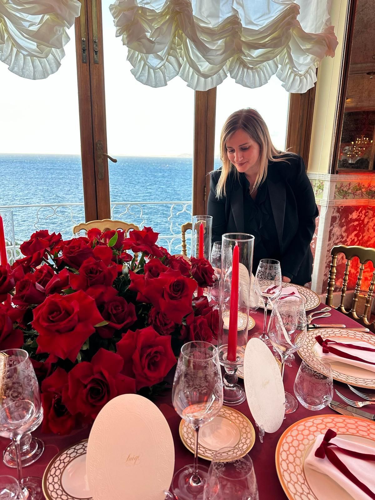 Un uomo e una donna sono in piedi sotto un arco rosa con cuori appesi al soffitto.