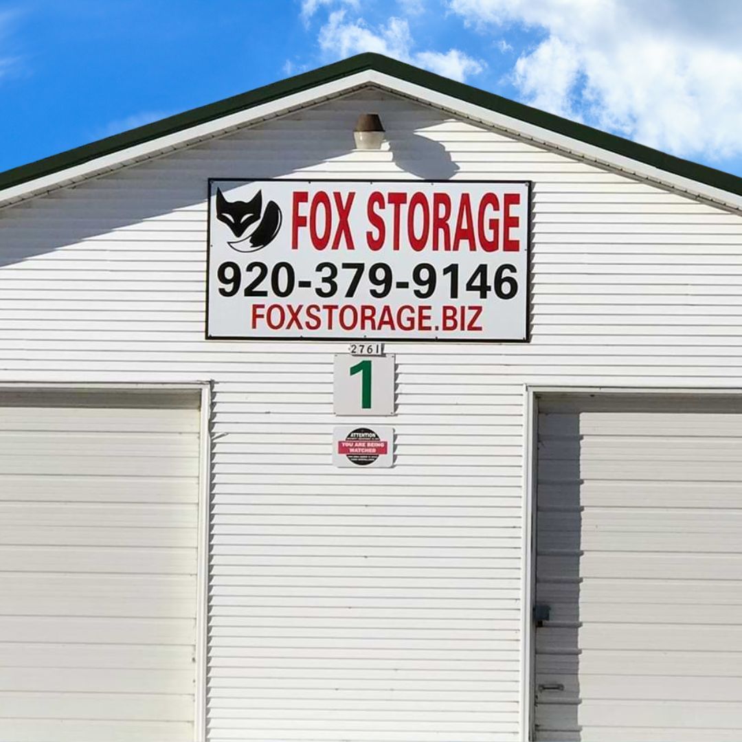 Fox Storage building with a sign and a green roof. Phone number and website are displayed.