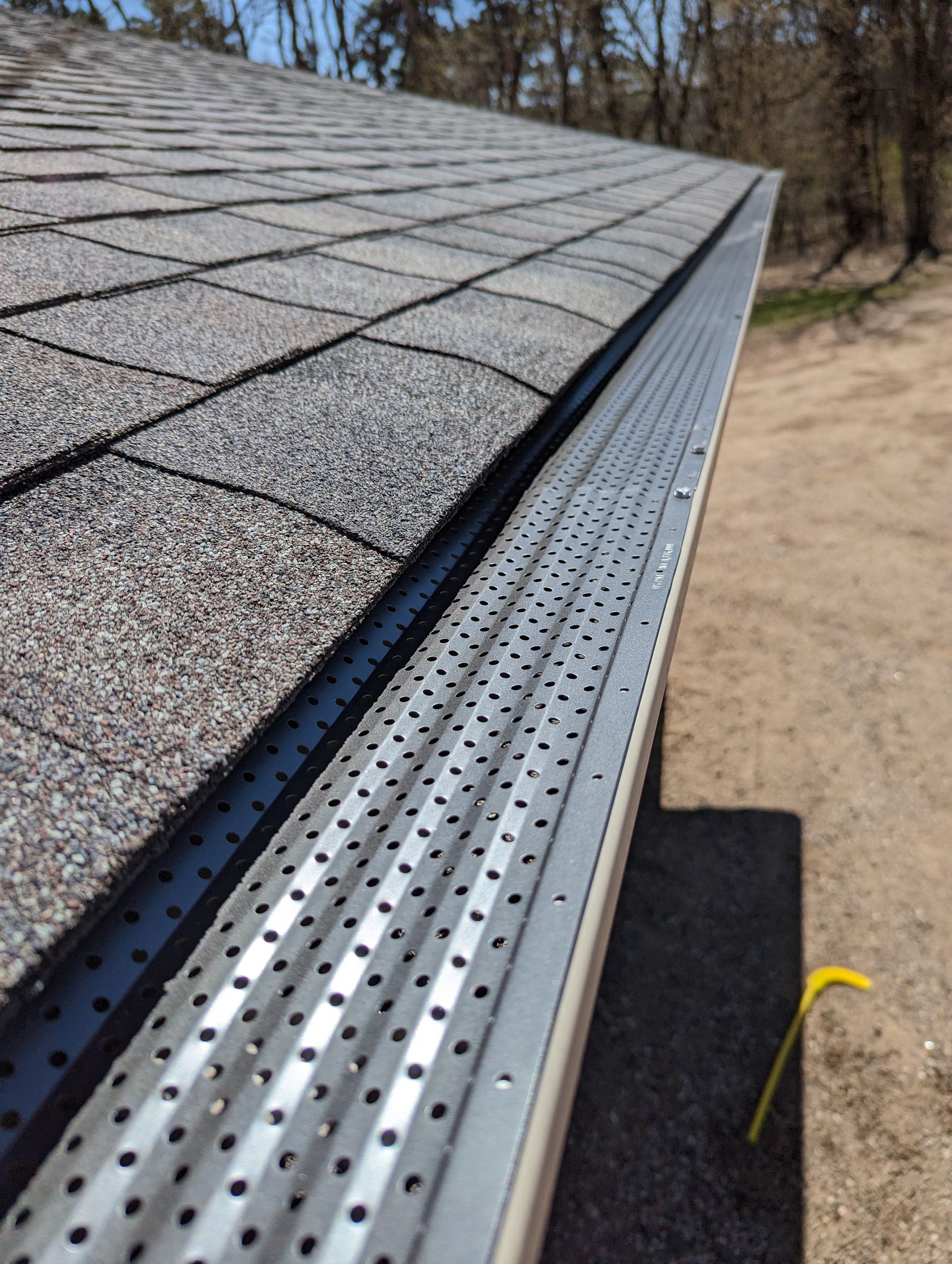 A close up of a gutter on the side of a roof.