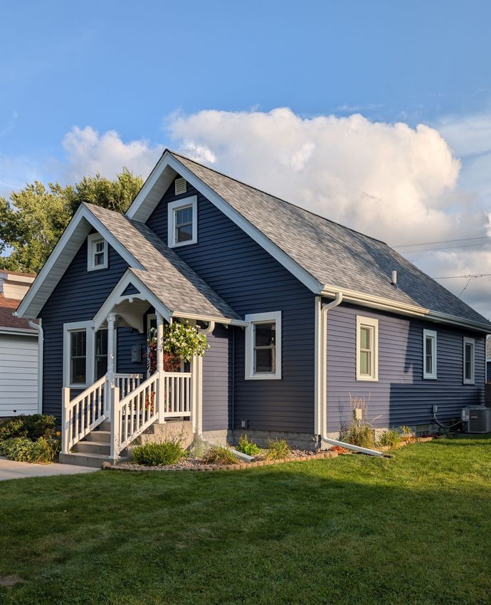 The front door of a house with a potted plant in front of it.