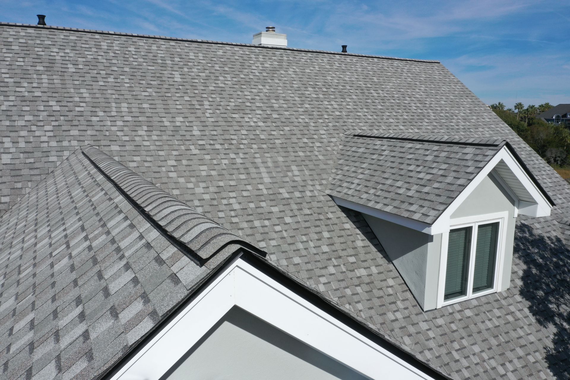 An aerial view of a house with a gray roof and a window.