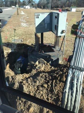 A person is digging a hole in the ground next to a box.