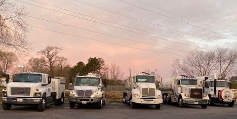 A row of trucks are parked next to each other in a parking lot.