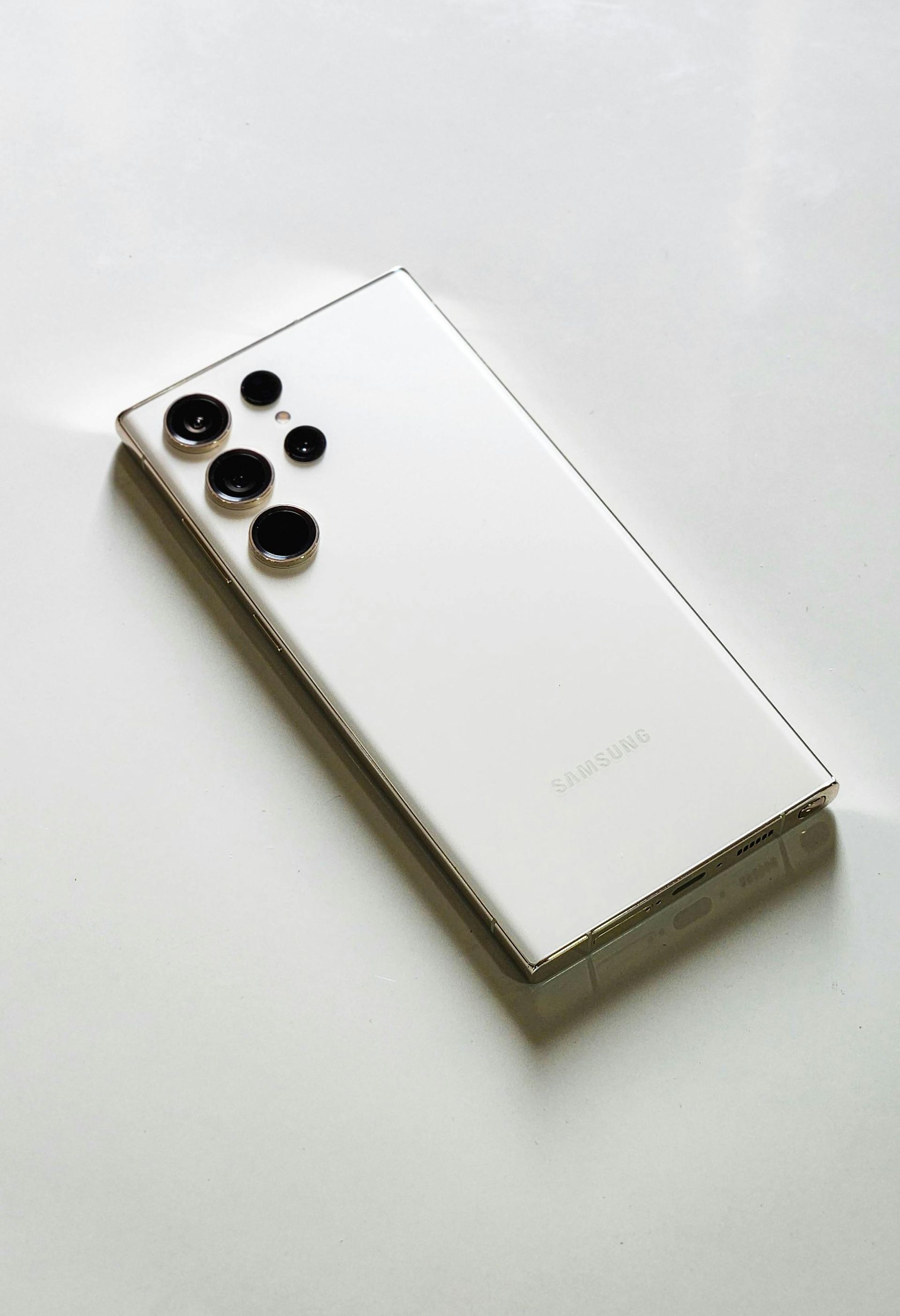 Two white smartphones in open boxes on a gray surface, one showing a blue screen image on the lid
