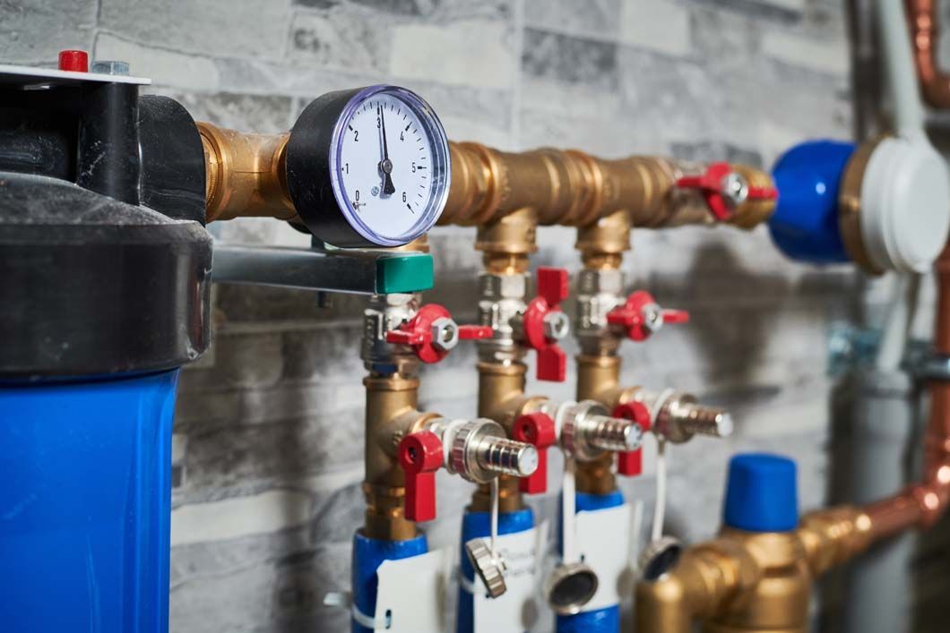 A close up of a water supply system with brass pipes and valves.