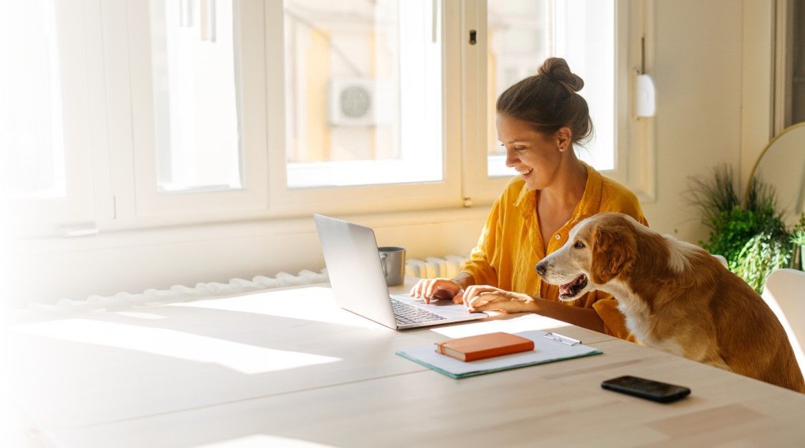 A woman is holding a pen in front of a laptop computer.