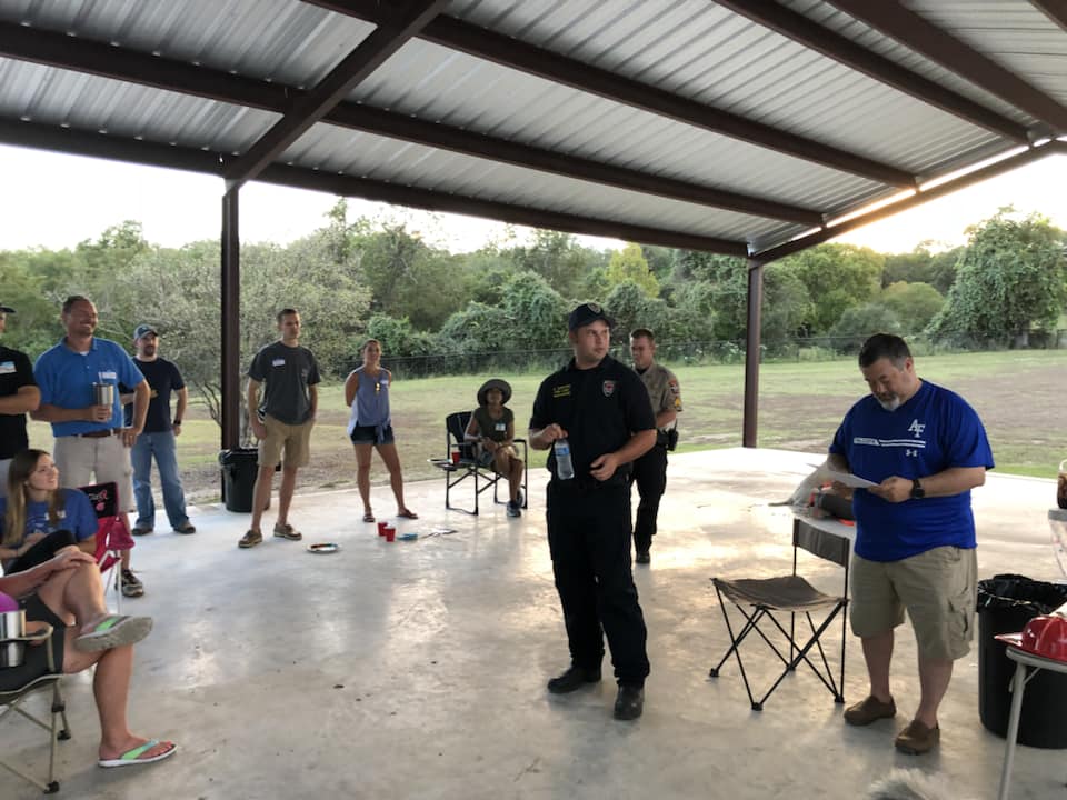 A group of people are standing under a covered area.