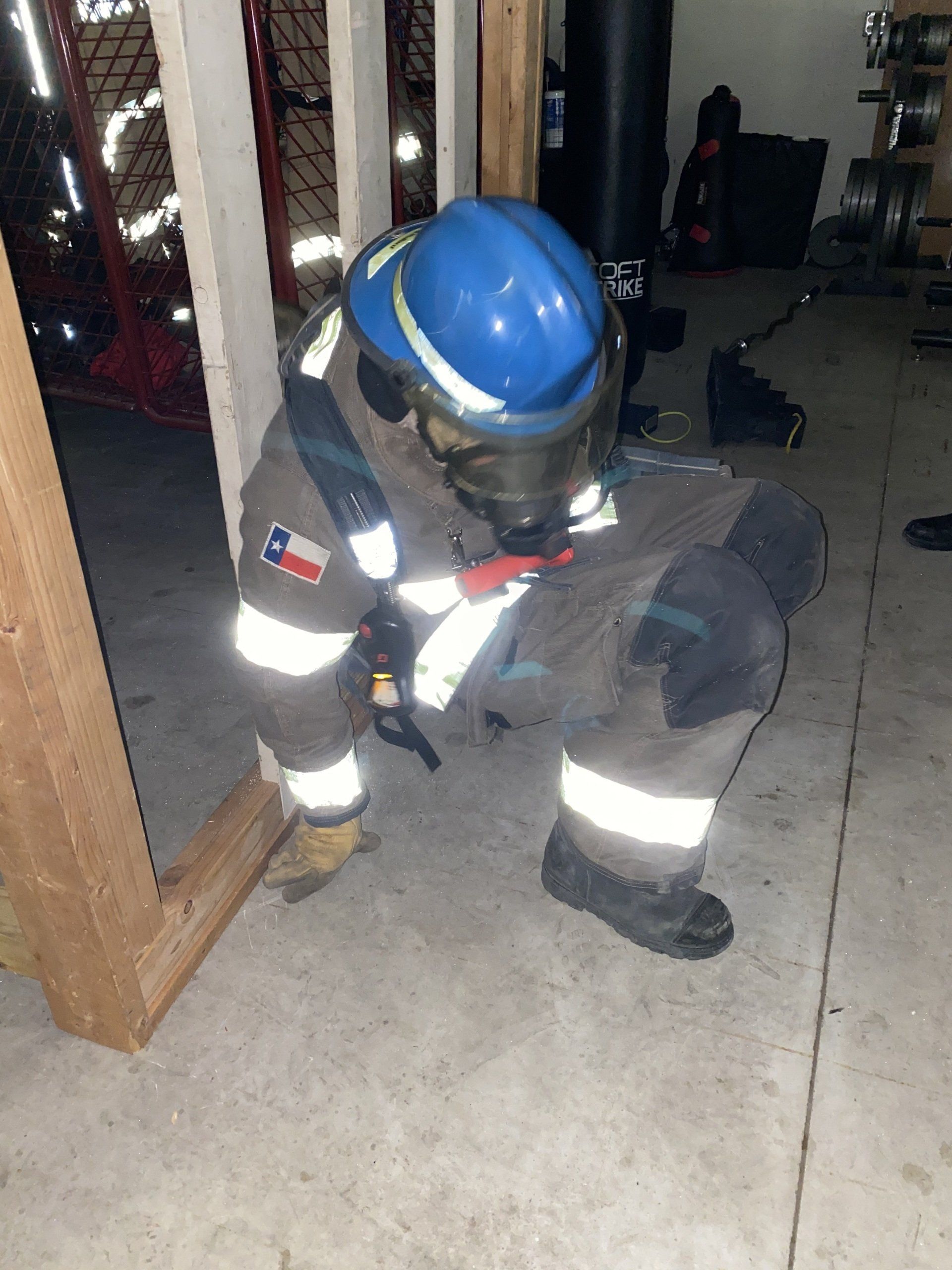 A fire fighter training on how to breach a wall.