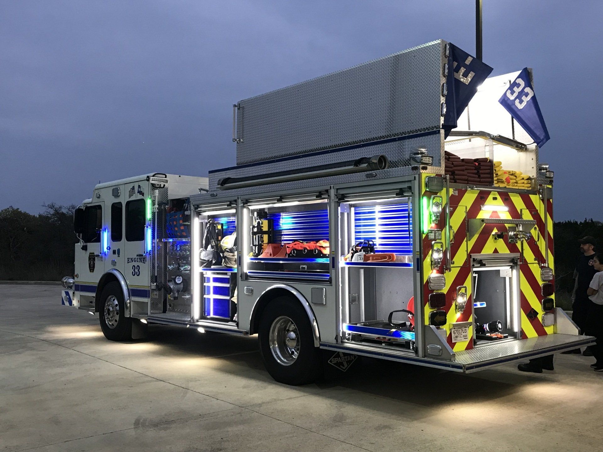 A fire truck is parked in a parking lot at night.