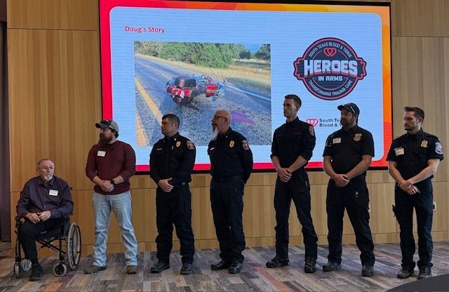Seven people stand in front of a screen displaying a car accident photo and 
