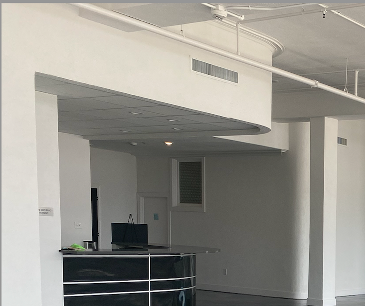 An empty room with white walls and a black counter