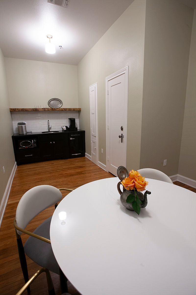 A white table with a vase of flowers on it in a kitchen.