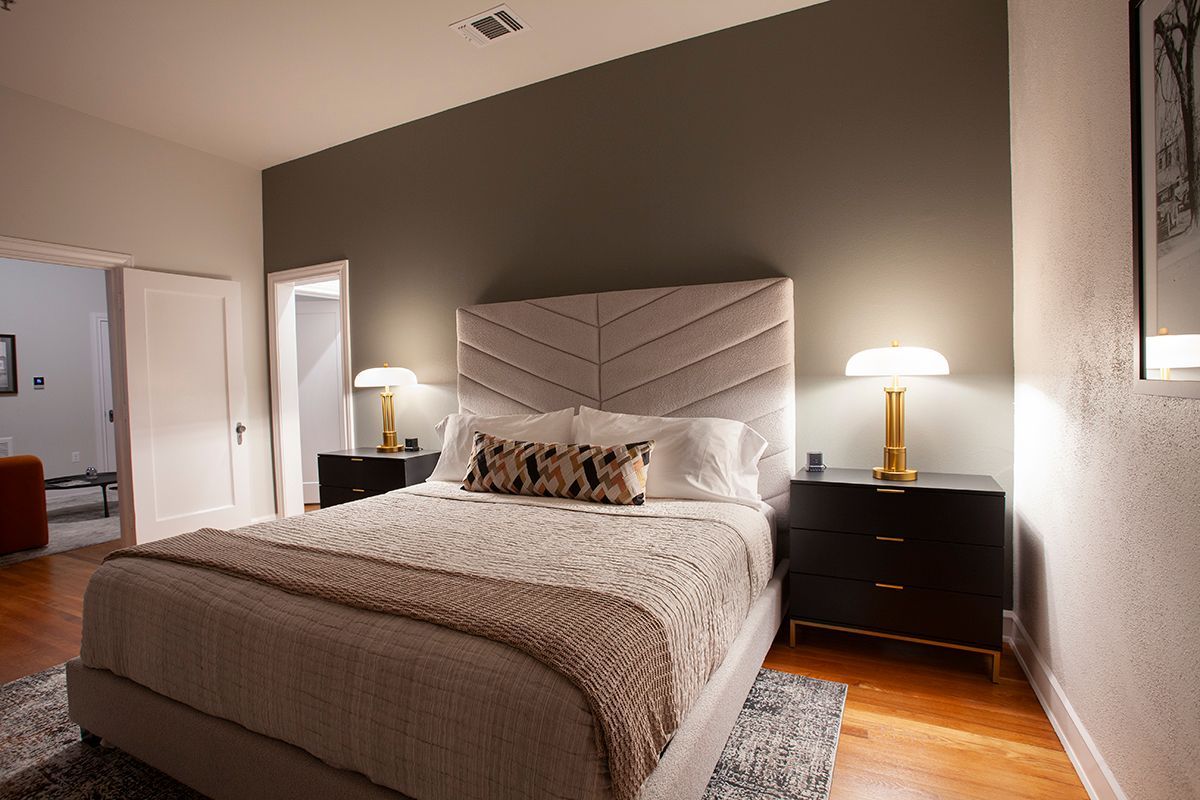 A bedroom with a king size bed , two nightstands , and two lamps.