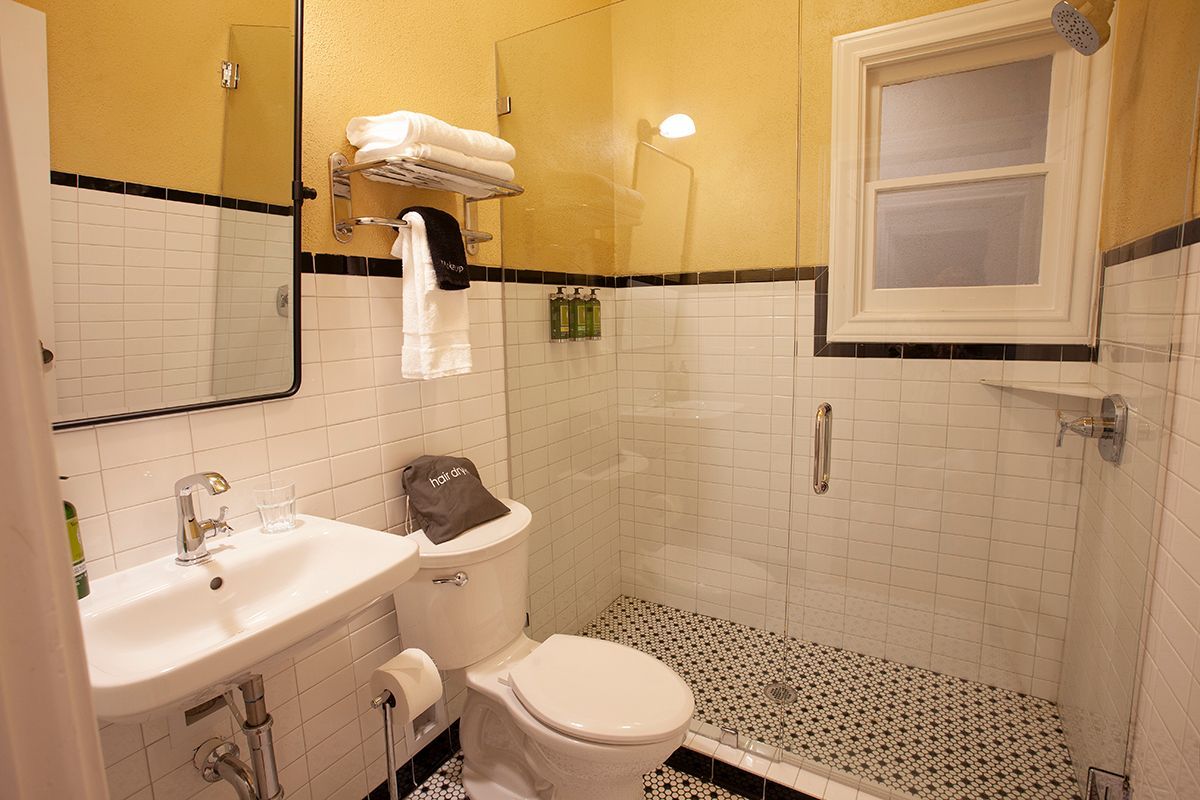 A bathroom with a toilet , sink and shower.