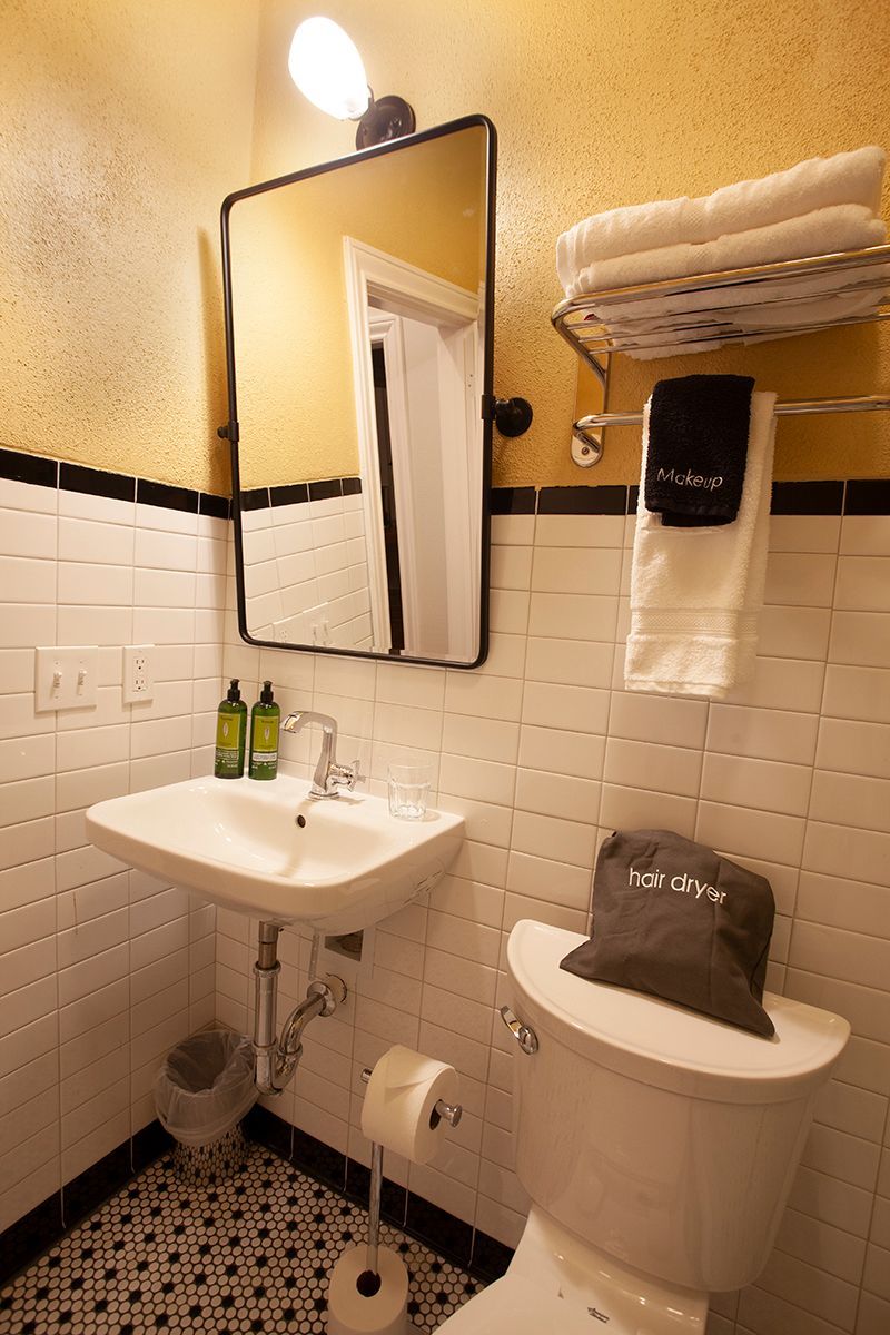 A bathroom with a sink , toilet , mirror and towels.