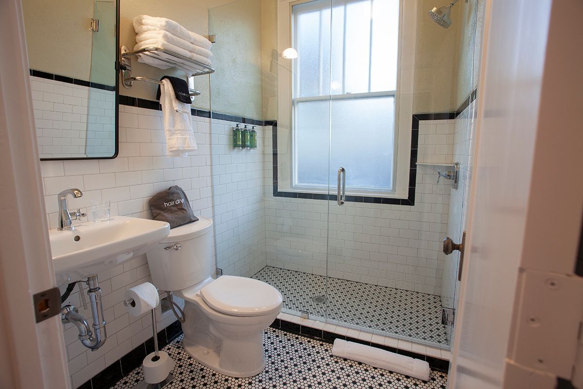 A bathroom with a toilet , sink and shower.