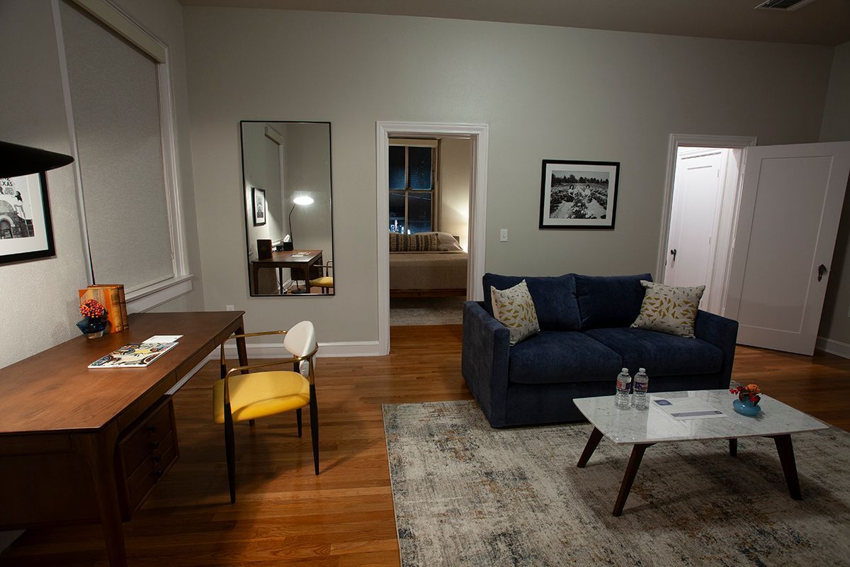 A living room with a couch , desk , chair and coffee table.