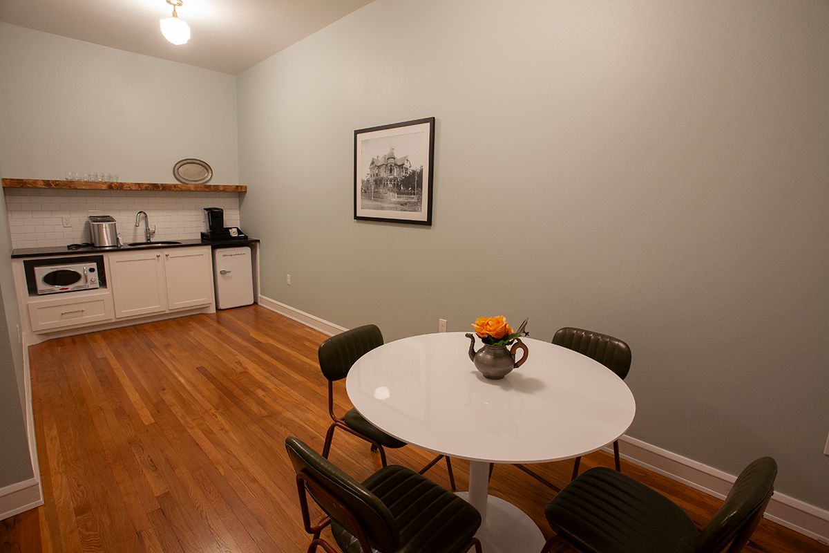 A kitchen with a table and chairs and a picture on the wall.