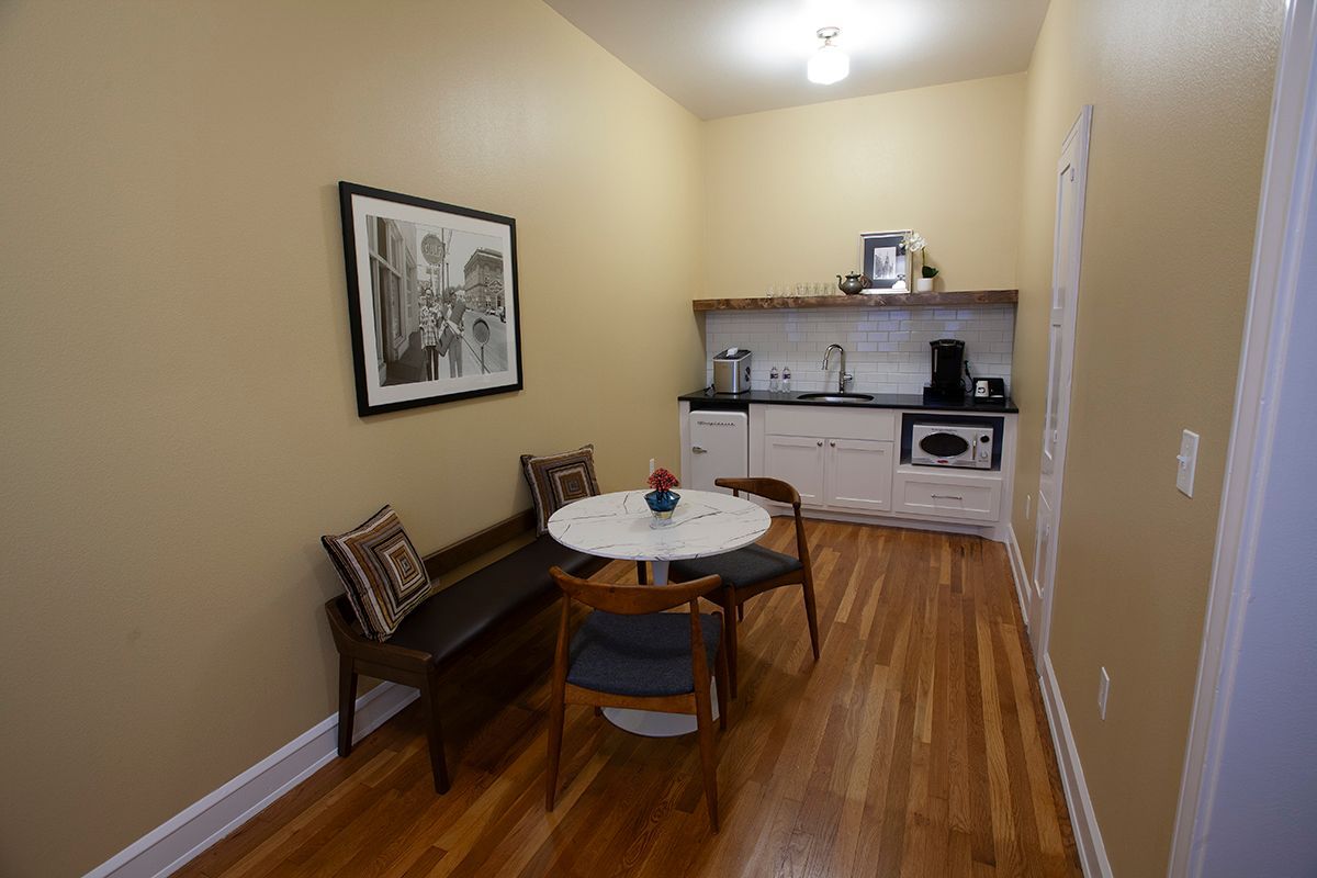 A kitchen with a table and chairs and a bench.