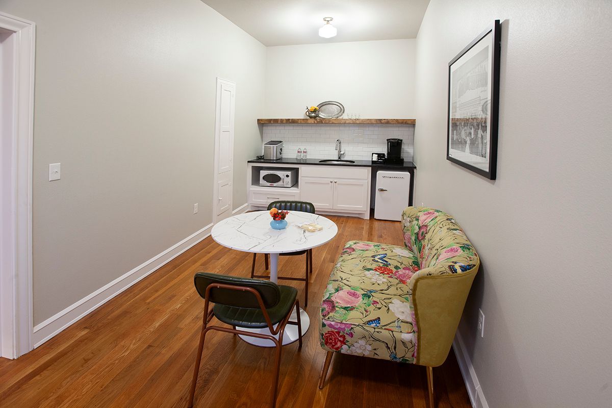 A living room with a table , chairs , and a couch.