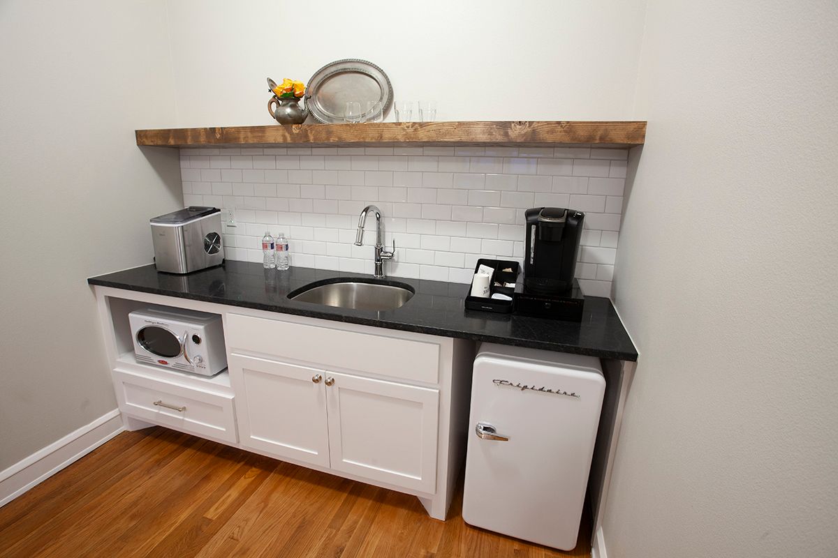 A kitchen with a sink , microwave , and refrigerator.