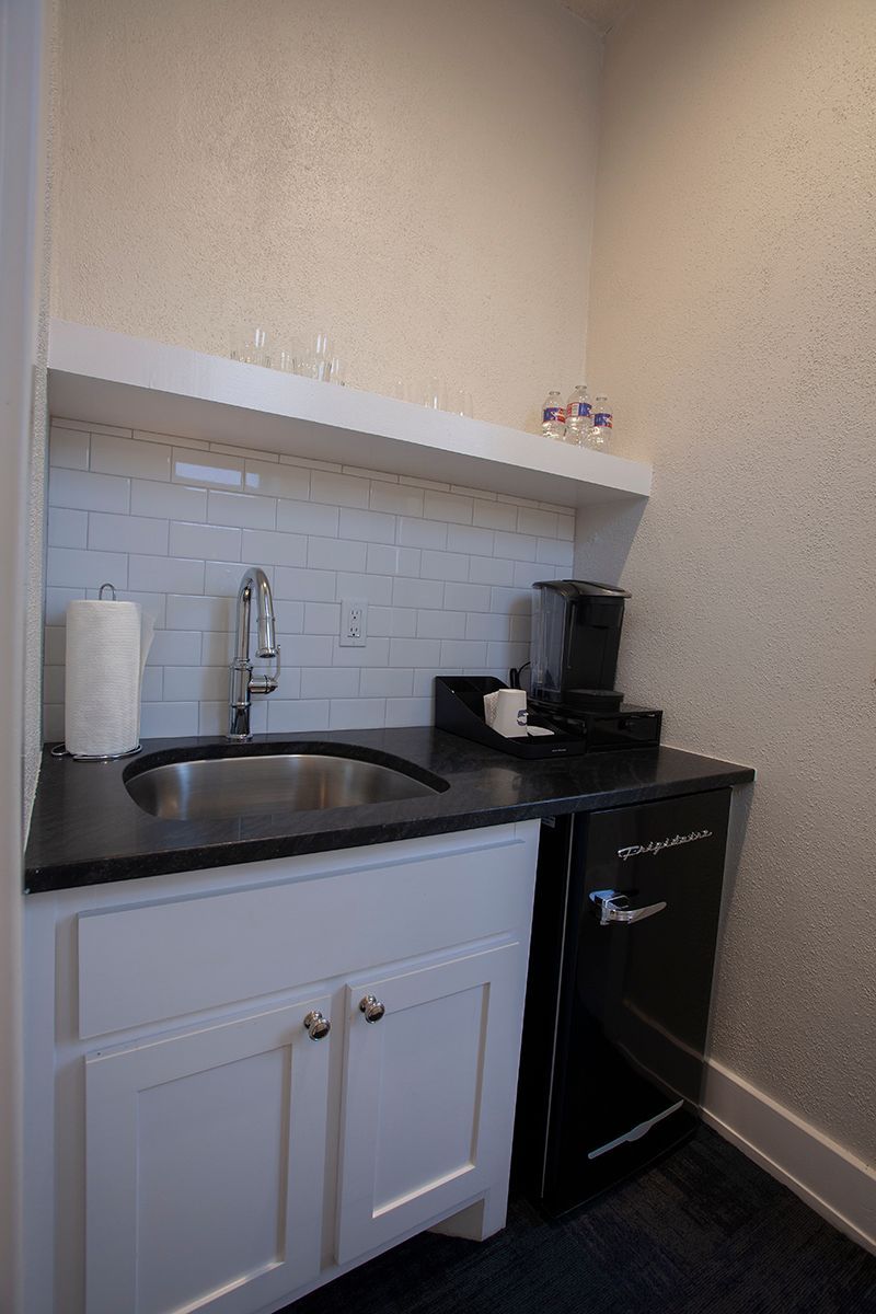 A kitchen with a sink and a coffee maker