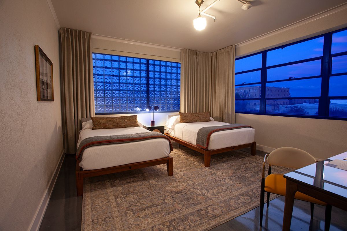 A hotel room with two beds , a table and chairs.