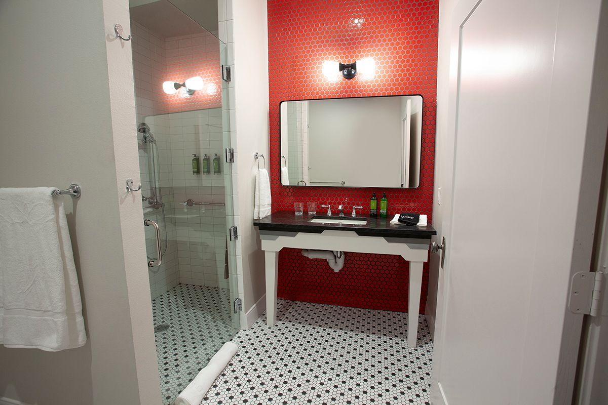 A bathroom with a sink , mirror , and shower.