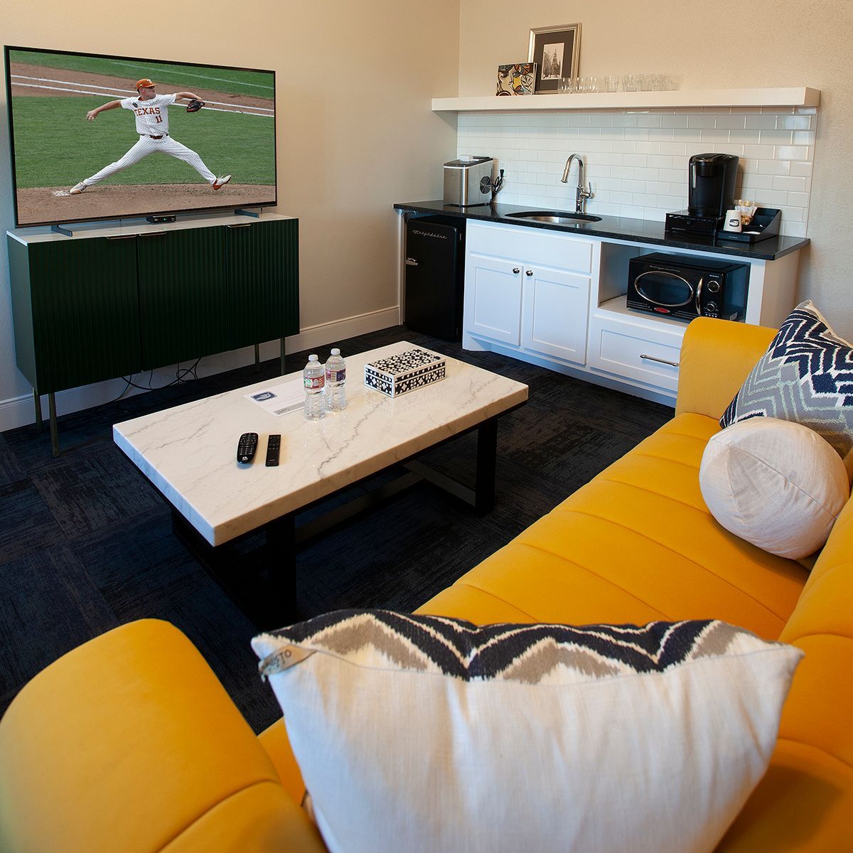A living room with a yellow couch and a flat screen tv