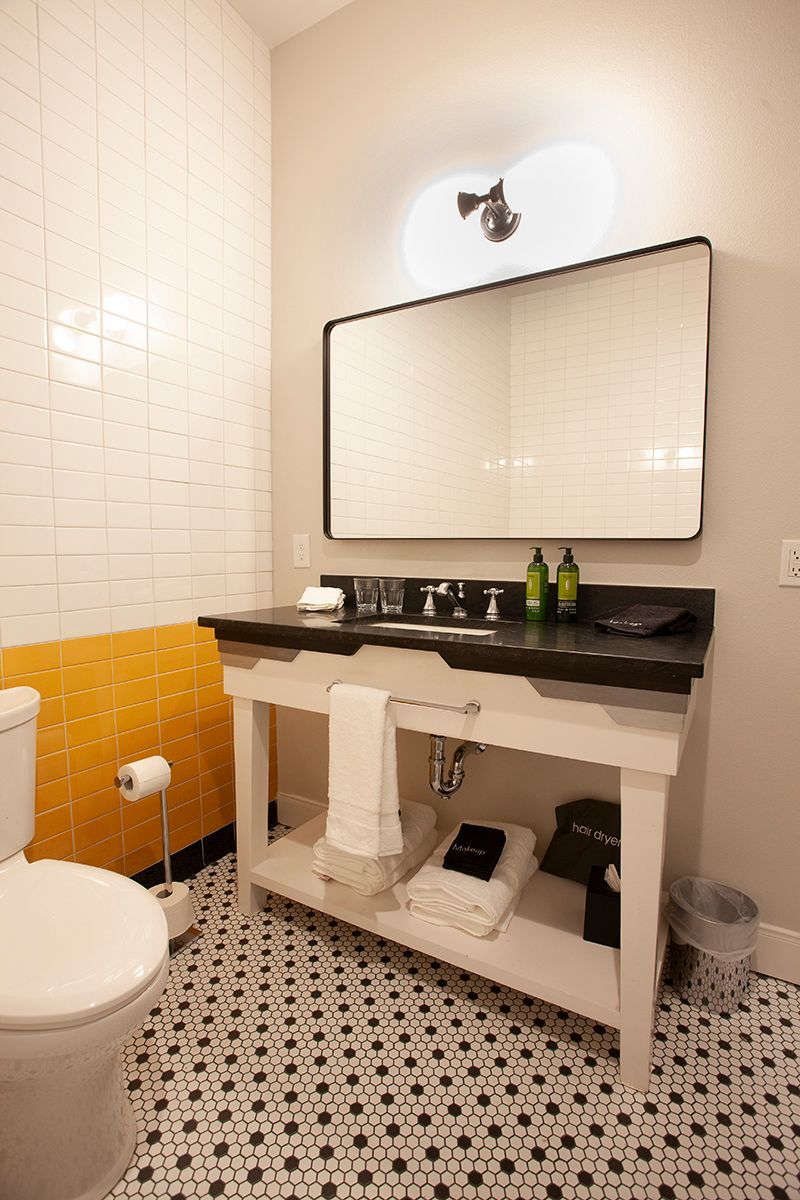 A bathroom with a toilet , sink and mirror.