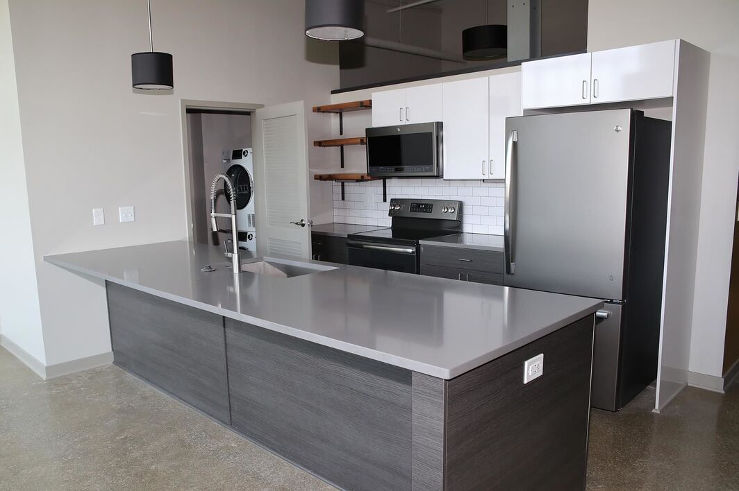 Modern kitchen with a large island and stainless steel appliances.