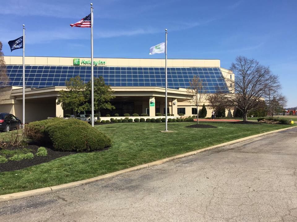 Holiday Inn hotel exterior with flags in front, a sunny day.