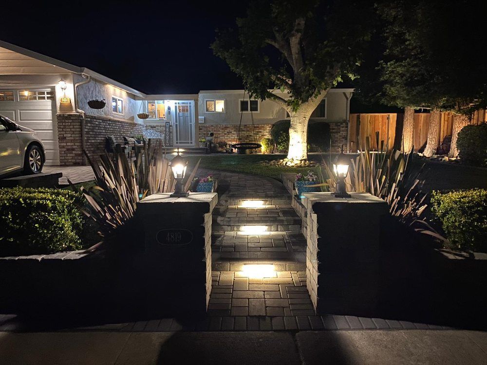 Night view of a house with lit steps and pathway leading to the front door.