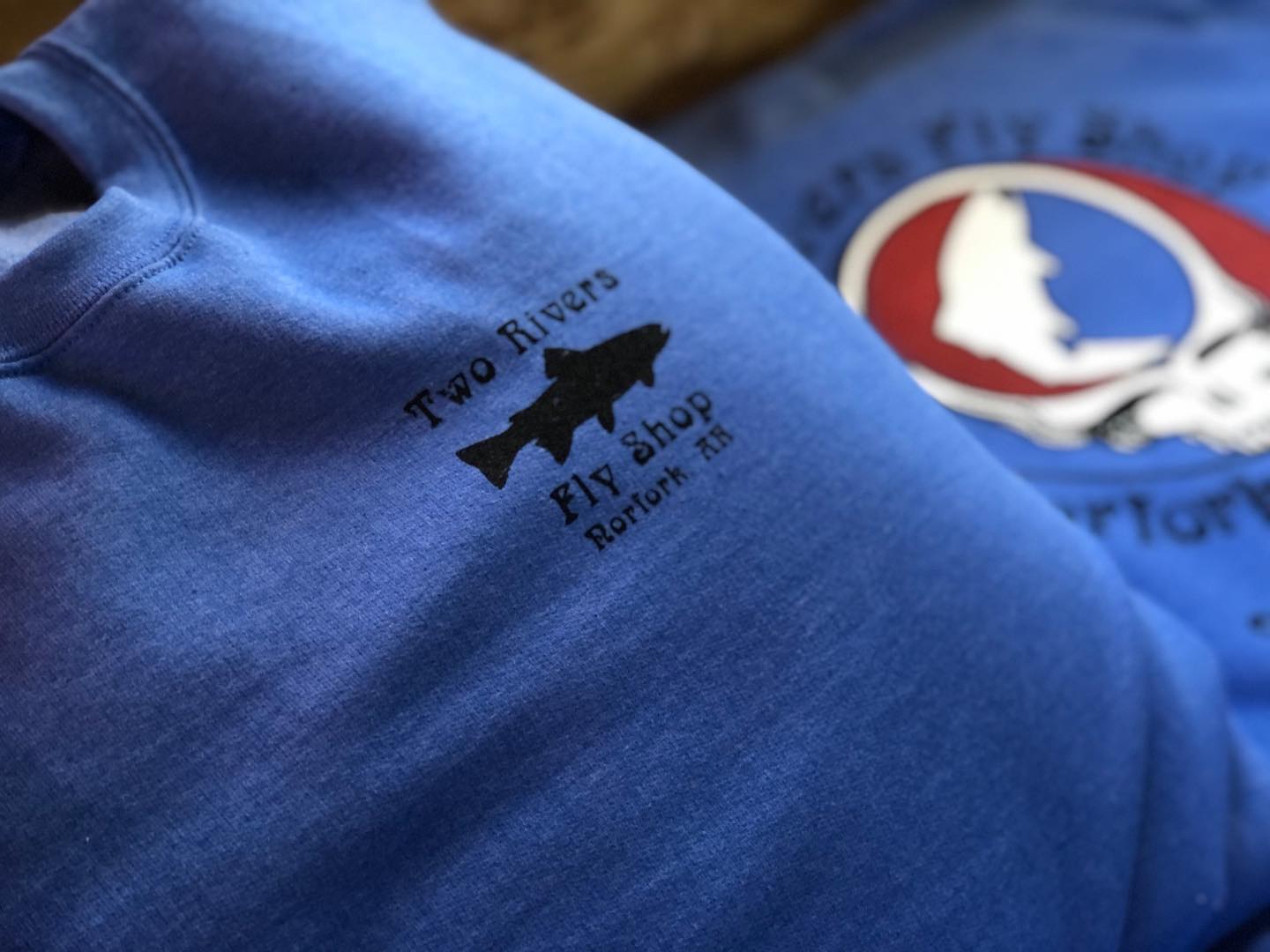 a blue shirt that says two rivers fly shop on it