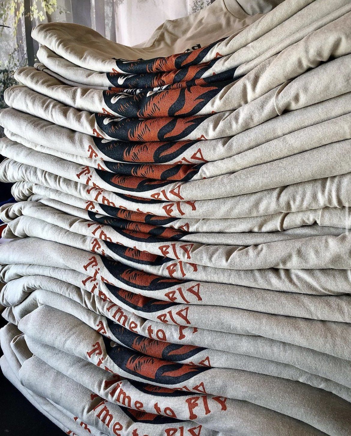 a stack of t-shirts sitting on top of each other on a table .