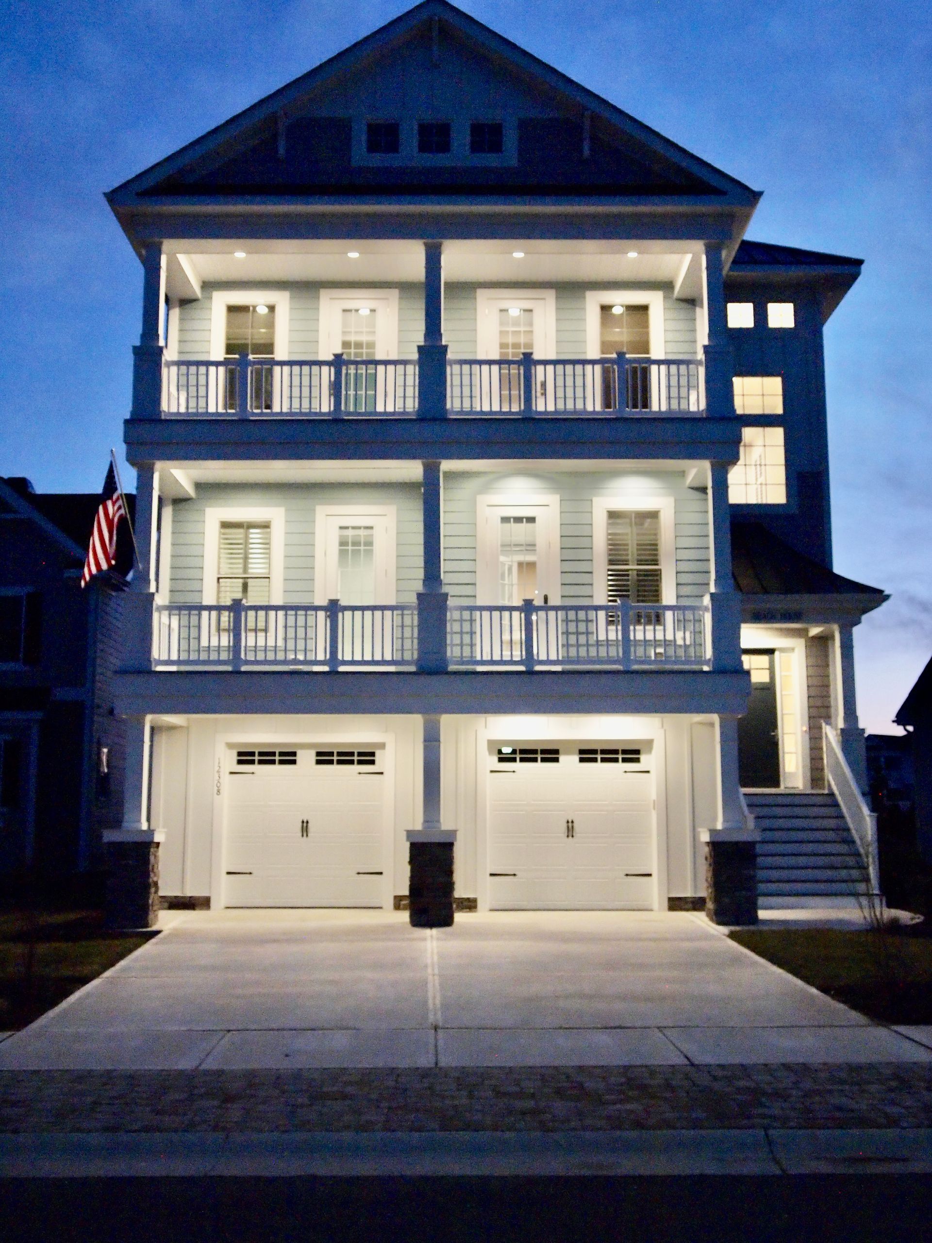 A woman is sitting at a desk with a laptop and a vase of flowers.
